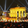 Spectators watch as giant, painted dominoes stand along the route of the former Berlin Wall.