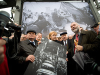 (From left) Former Soviet leader Mikhail Gorbachev, German Chancellor Angela Merkel and former Polish president Lech Walesa hold a signed print of people crossing the Boesbrucke border bridge as they cross the same bridge during a ceremony to mark the 20th anniversary of the fall of the wall in Berlin on Monday.