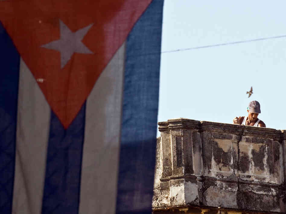 A Cuban works next to a national flag in Havana in August.