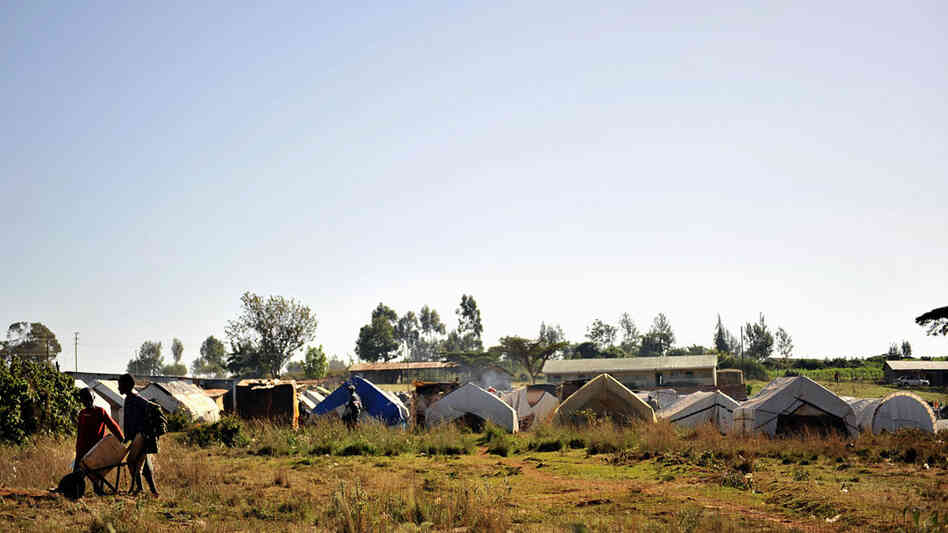 W: Two boys push a wheelbarrow outside an IDP camp for members of the Kikuyu tribe in Eldoret, Kenya W: Two boys push a wheelbarrow outside an IDP camp for members of the Kikuyu tribe in Eldoret, Kenya