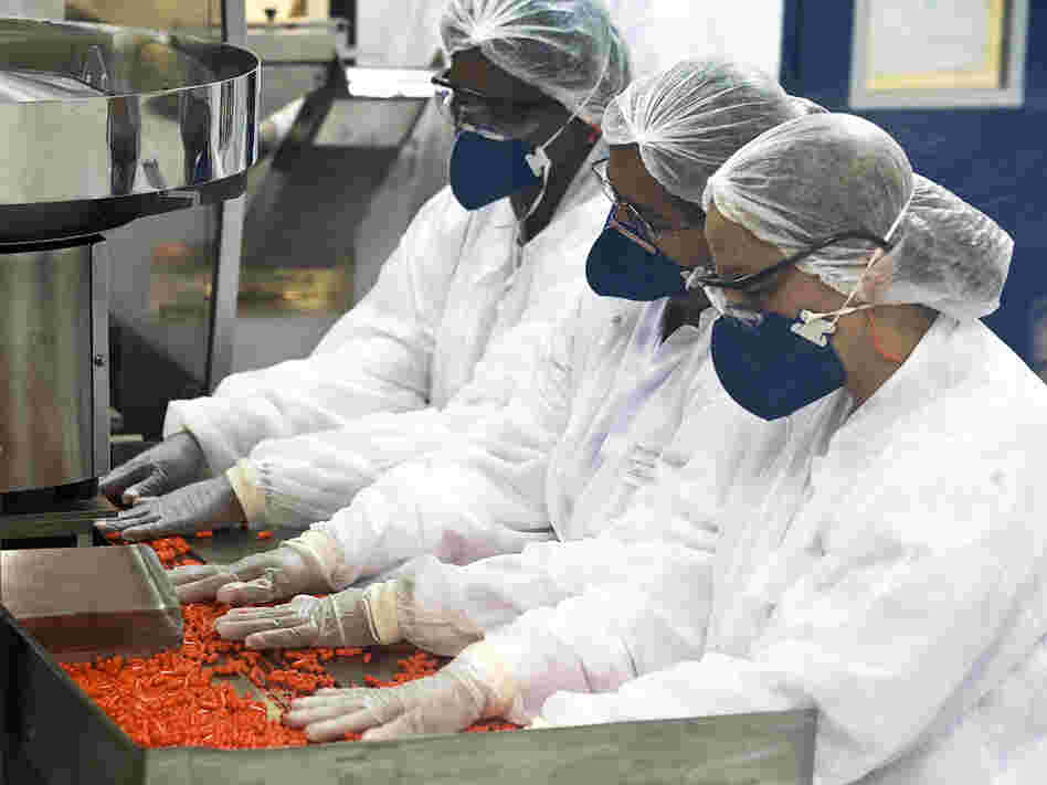 Workers at a Brazilian government  lab pack pills of Oseltamivir, similar to Tamiflu.