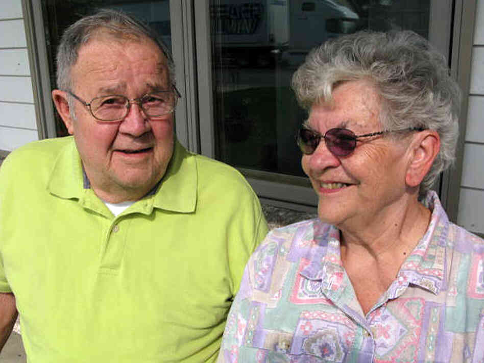 Joe Hauser sits with his wife on their porch.