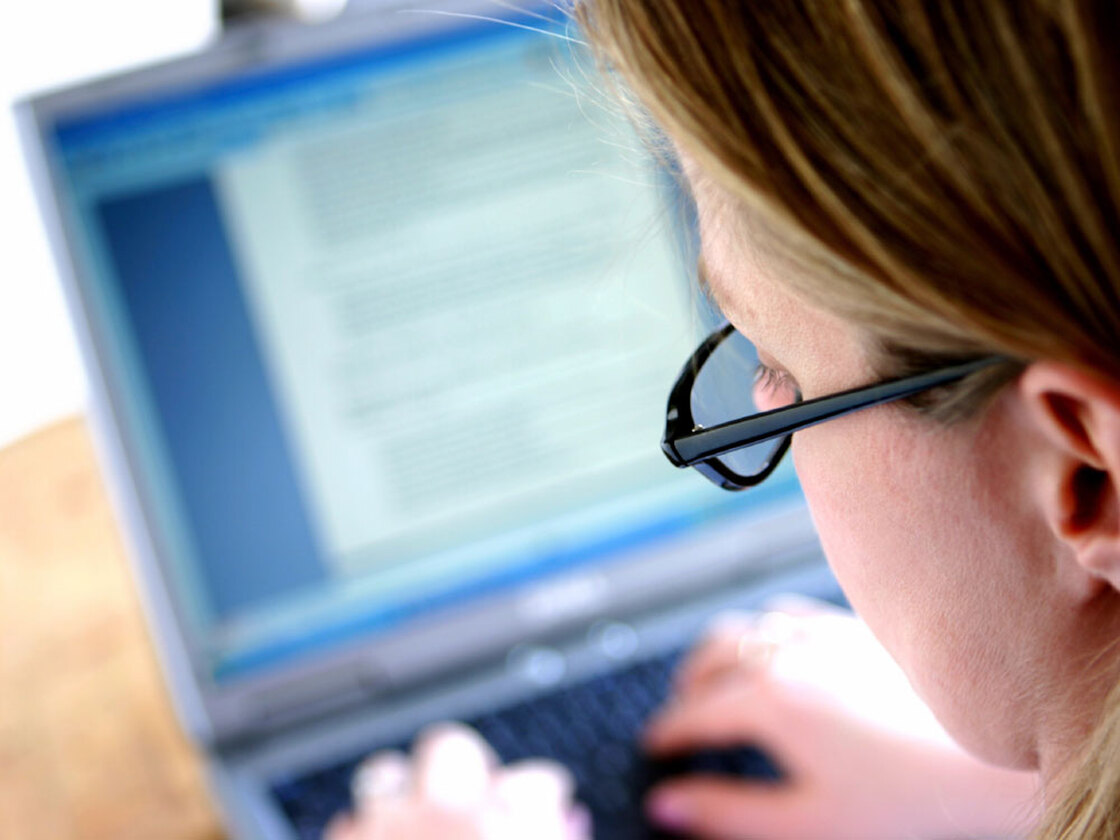 A woman types on her computer.