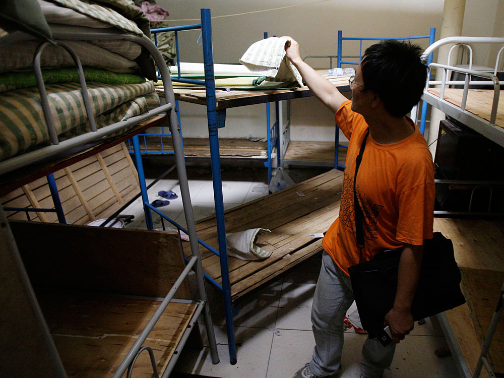 Human rights activist Liu Dejun looks through a room in a 