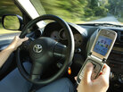A driver uses a cell phone in Freeport, Maine. A driver uses a cell phone in Freeport, Maine.