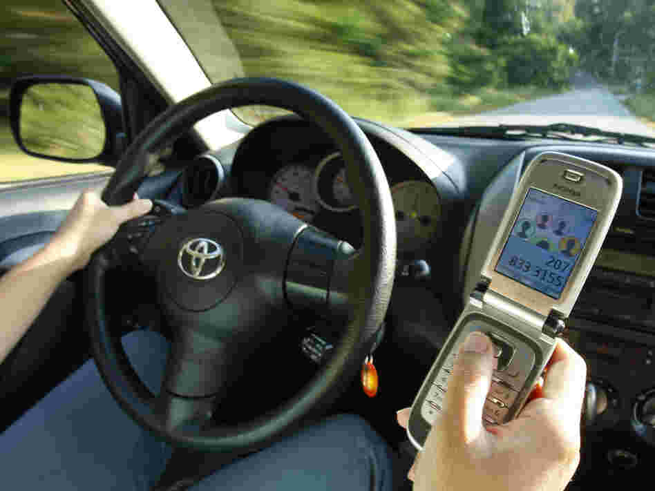 A driver uses a cell phone in Freeport, Maine.