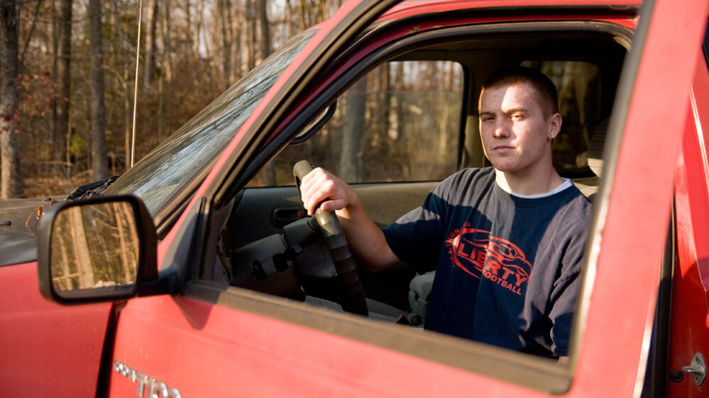 Basil Rynestead, 17, sits in the driver's seat of his Toyota pickup truck.