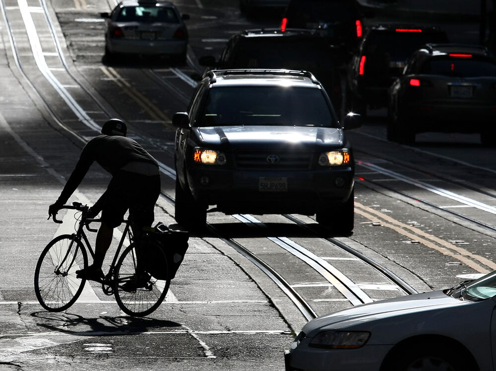 A bicyclist rides his bike down the street in San Francisco.