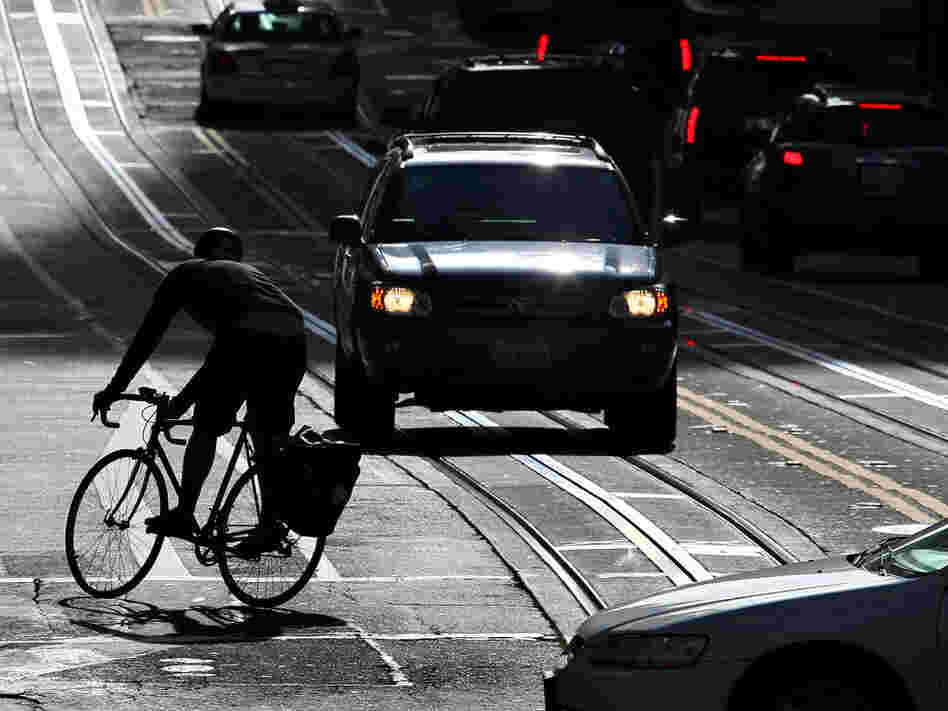 A bicyclist rides his bike down the street in San Francisco.