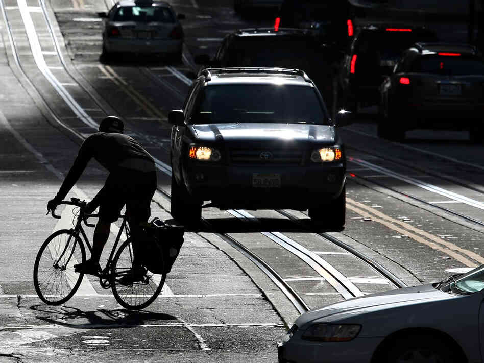A bicyclist rides his bike down the street in San Francisco.