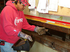 Carlos Chavez cuts sheet metal to repair a tortilla-making machine. Carlos Chavez cuts sheet metal to repair a tortilla-making machine.