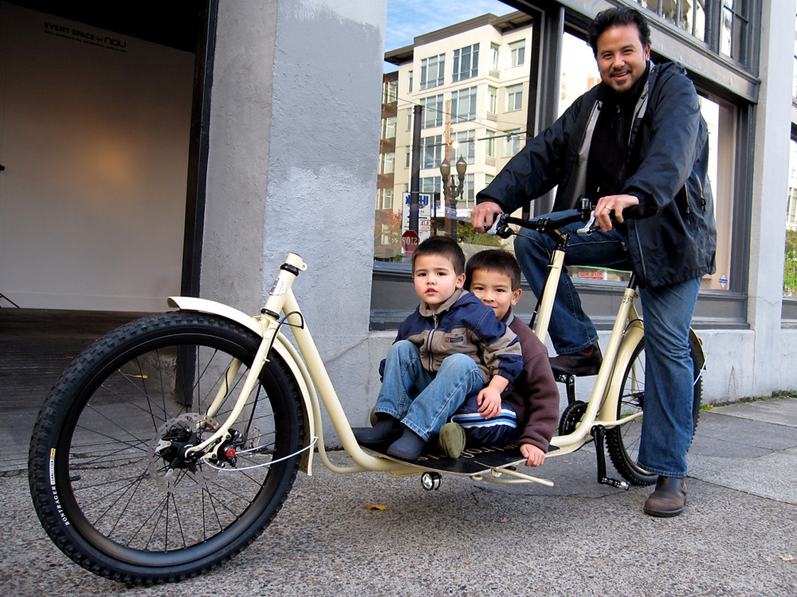 A cyclist and boys ride one of Metrofiets' cargo bikes.