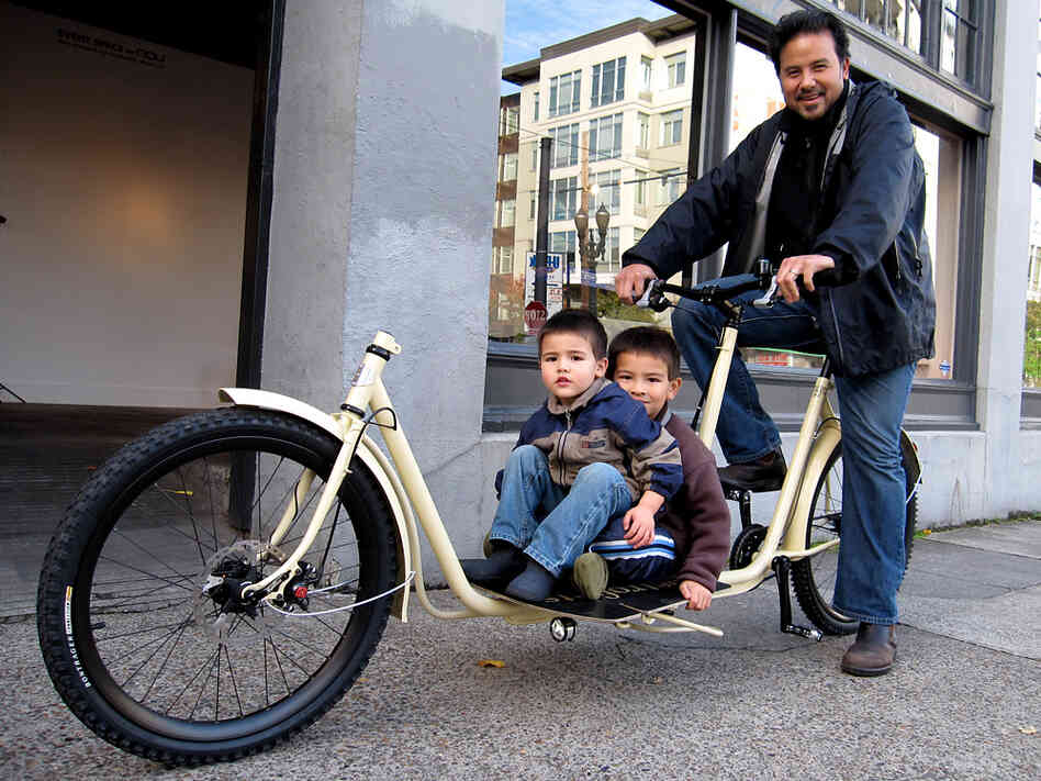 A cyclist and boys ride one of Metrofiets' cargo bikes.