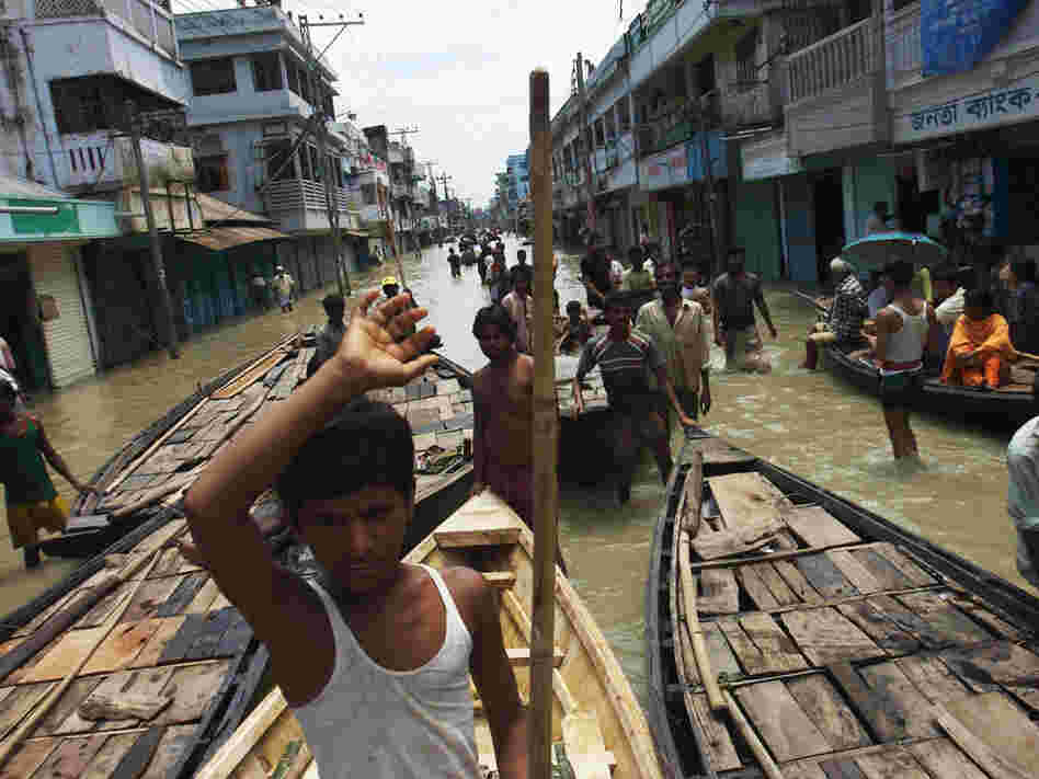 Boats vie for passengers at a flooded intersection in downtown Sirajganj, Bangladesh