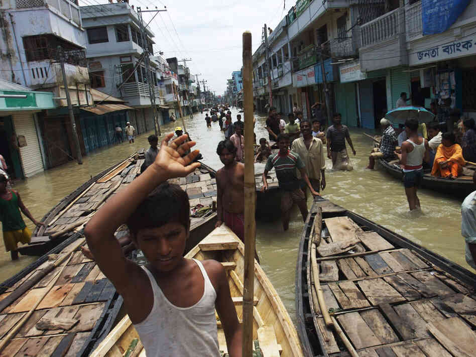 Boats vie for passengers at a flooded intersection in downtown Sirajganj, Bangladesh