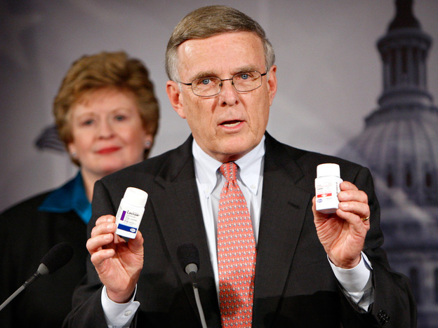 Sen. Byron Dorgan (D-N.D.) holds up examples of prescription drugs during a news conference in March