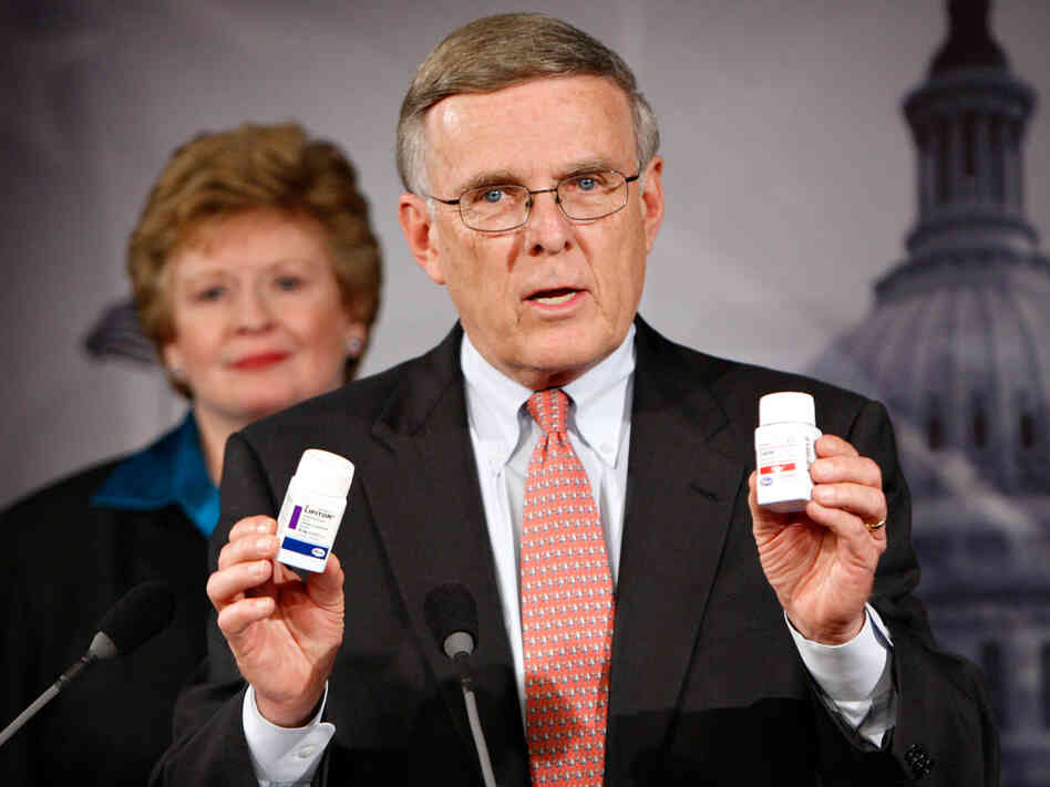 Sen. Byron Dorgan (D-N.D.) holds up examples of prescription drugs during a news conference in March