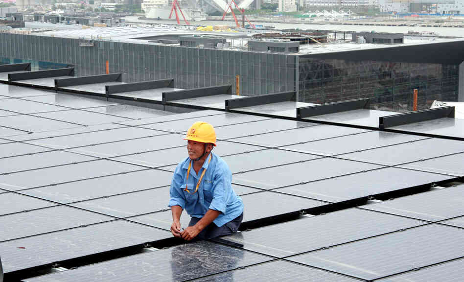 A Chinese worker installs solar panels on the rooftop