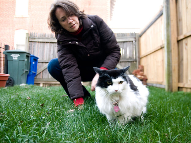 Anne Croft pets her cat, Wilhelmina, in her Washington backyard.