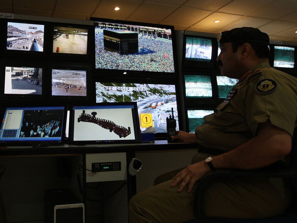 Saudi police officers monitor screens connected to cameras set up at holy places near Mecca.