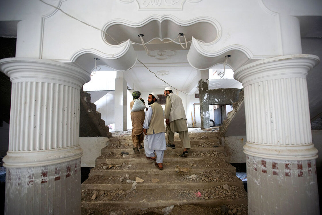 Contractors walk through an apartment complex in Afghanistan.