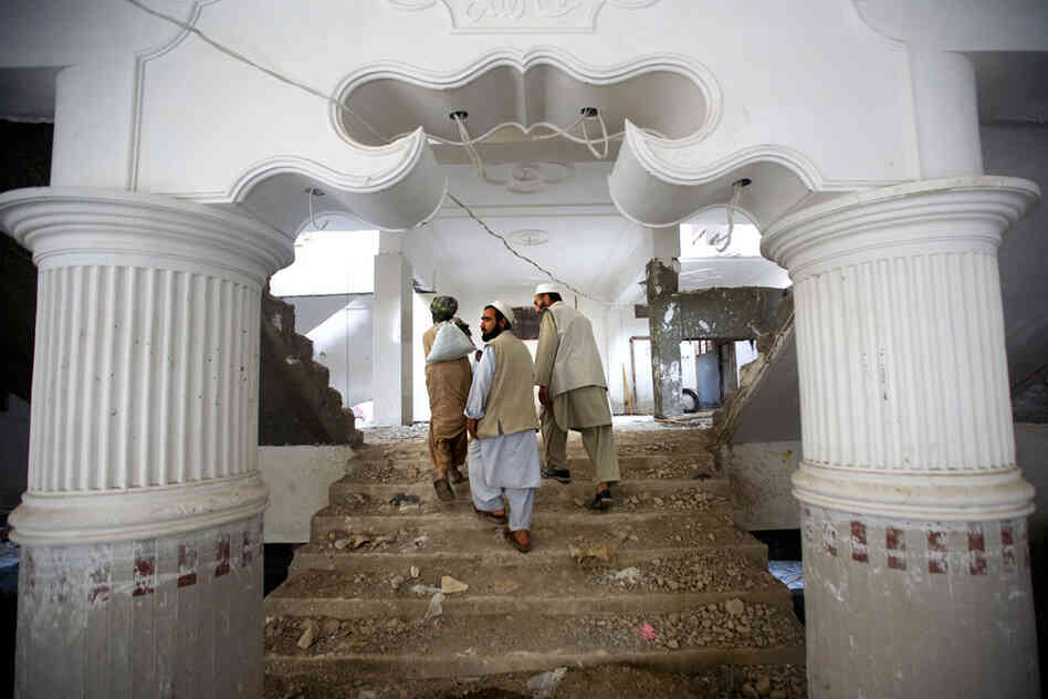 Contractors walk through an apartment complex in Afghanistan.