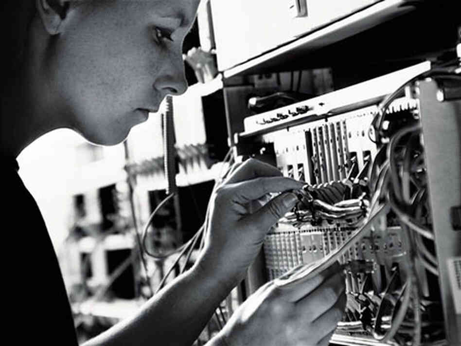 A technician checks a networking cable. A technician checks a networking cable.