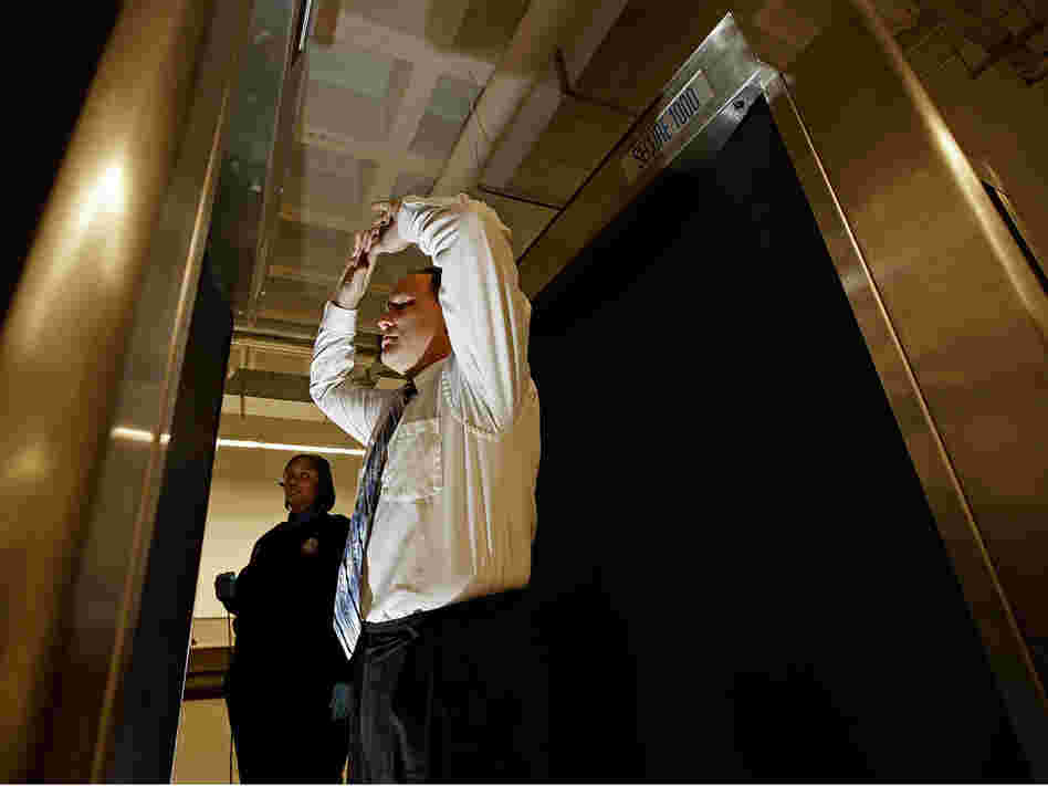 A man stands inside a backscatter scanner at Ronald Reagan National Airport.