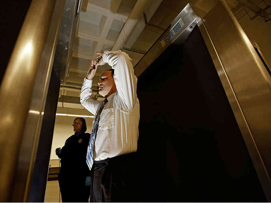 A man stands inside a backscatter scanner at Ronald Reagan National Airport.