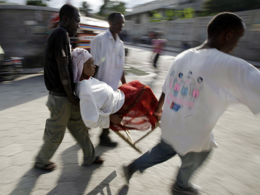 A woman is carried in a chair amidst destruction from the earthquake in Port-au-Prince. A woman is carried in a chair amidst destruction from the earthquake in Port-au-Prince.