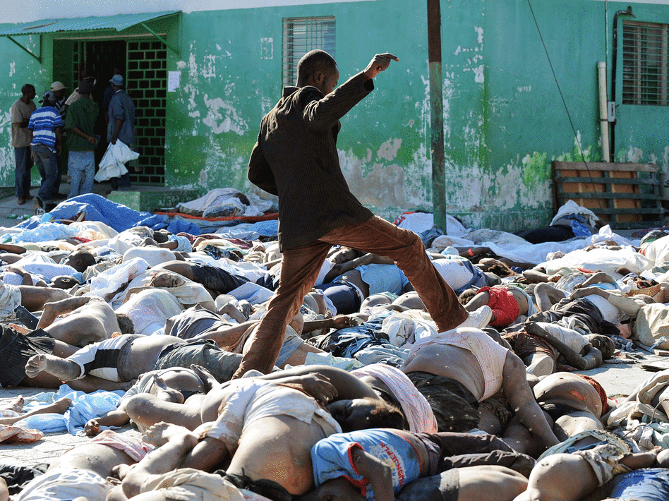 A man makes his way through lifeless bodies in Haiti.