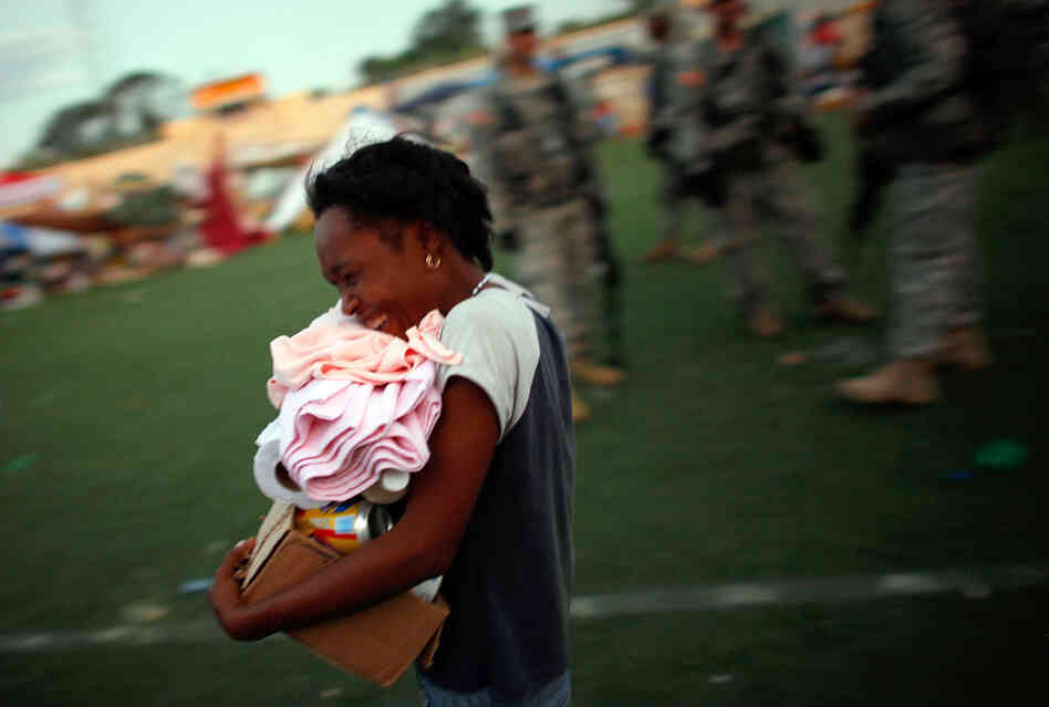 A Haitian woman receives her first ration of foreign aid in a soccer stadium A Haitian woman receives her first ration of foreign aid in a soccer stadium
