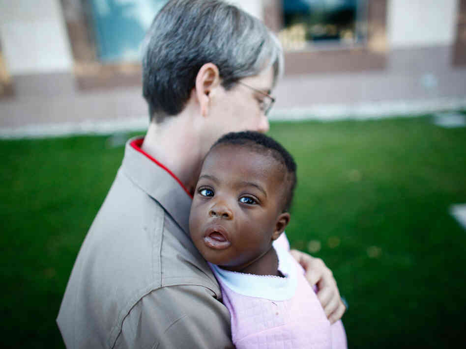 EMT Melinda Pethel carries an infant into the American Embassy in Port-au-Prince.