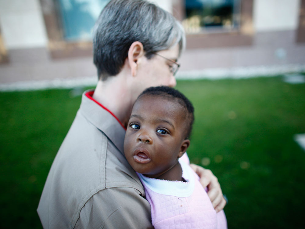 EMT Melinda Pethel carries an infant into the American Embassy in Port-au-Prince.