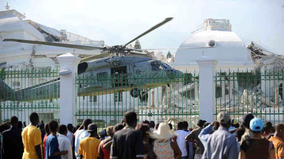 Haitians watch as a U.S. Navy helicopter lands at the presidential palace in Port-au-Prince. Haitians watch as a U.S. Navy helicopter lands at the presidential palace in Port-au-Prince.