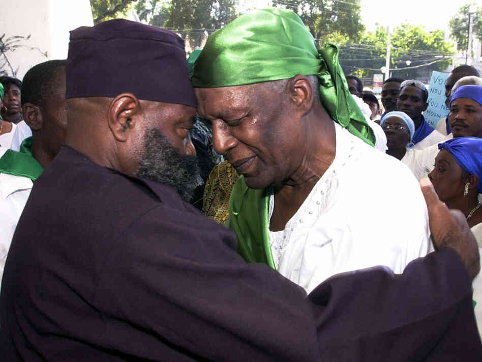 Voodoo priest Max Beauvoir and another man pray during a Voodoo demonstration.