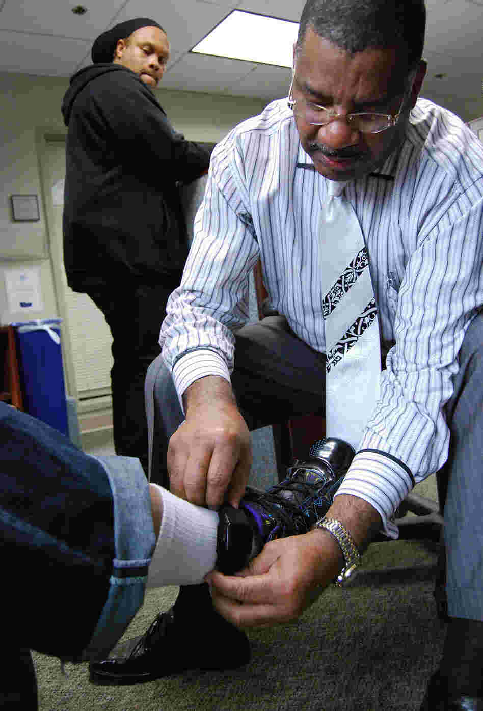 A program manager for the D.C. Pretrial Services Agency adjusts a defendant's ankle bracelet. A program manager for the D.C. Pretrial Services Agency adjusts a defendant's ankle bracelet.