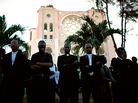 Haitian priests listen to the service for the two clergymen in front of the destroyed cathedral. Haitian priests listen to the service for the two clergymen in front of the destroyed cathedral.
