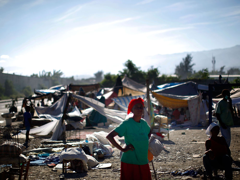 A woman stands near a makeshift refugee camp near downtown Port-au-Prince A woman stands near a makeshift refugee camp near downtown Port-au-Prince