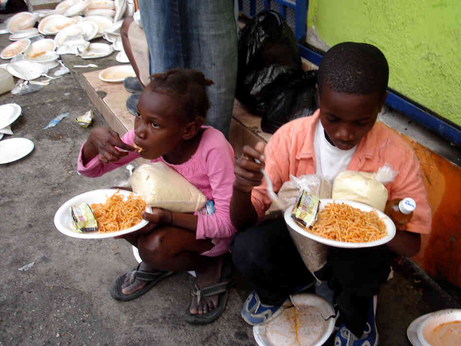 Children eat a free spaghetti meal at Muncheez restaurant in Petionville, Haiti