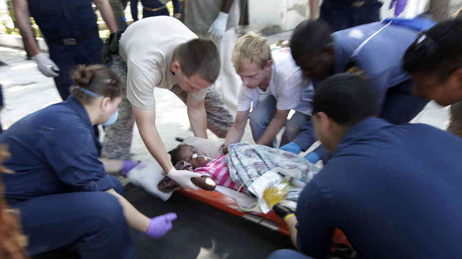 U.S. military personnel prepared to airlift an injured girl to an offshore medical facility. U.S. military personnel prepared to airlift an injured girl to an offshore medical facility.