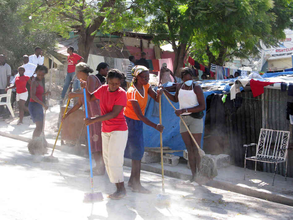 Women sweep the street in an impoverished area outside of Port-au-Prince, Haiti. Women sweep the street in an impoverished area outside of Port-au-Prince, Haiti.
