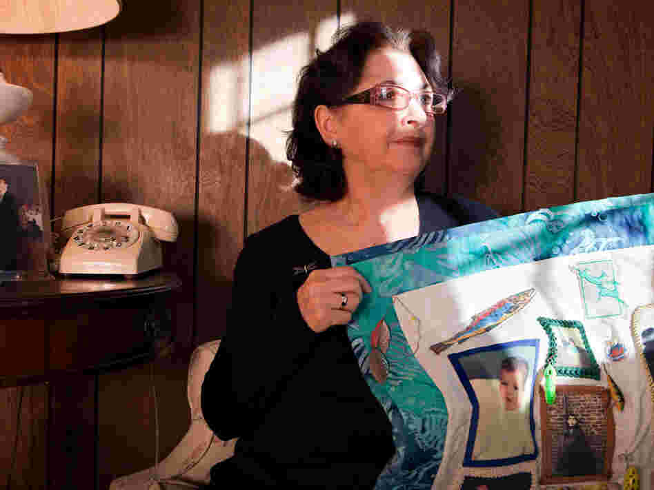 Lorenza Colletti holds a quilt in homage to her 26-year-old son who died in 1995.