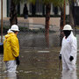 Workers clear a flooded intersection after heavy rain in California.