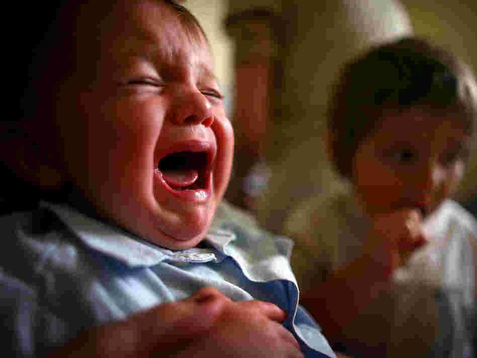 A young boy reacts to receiving a prick from a vaccine.