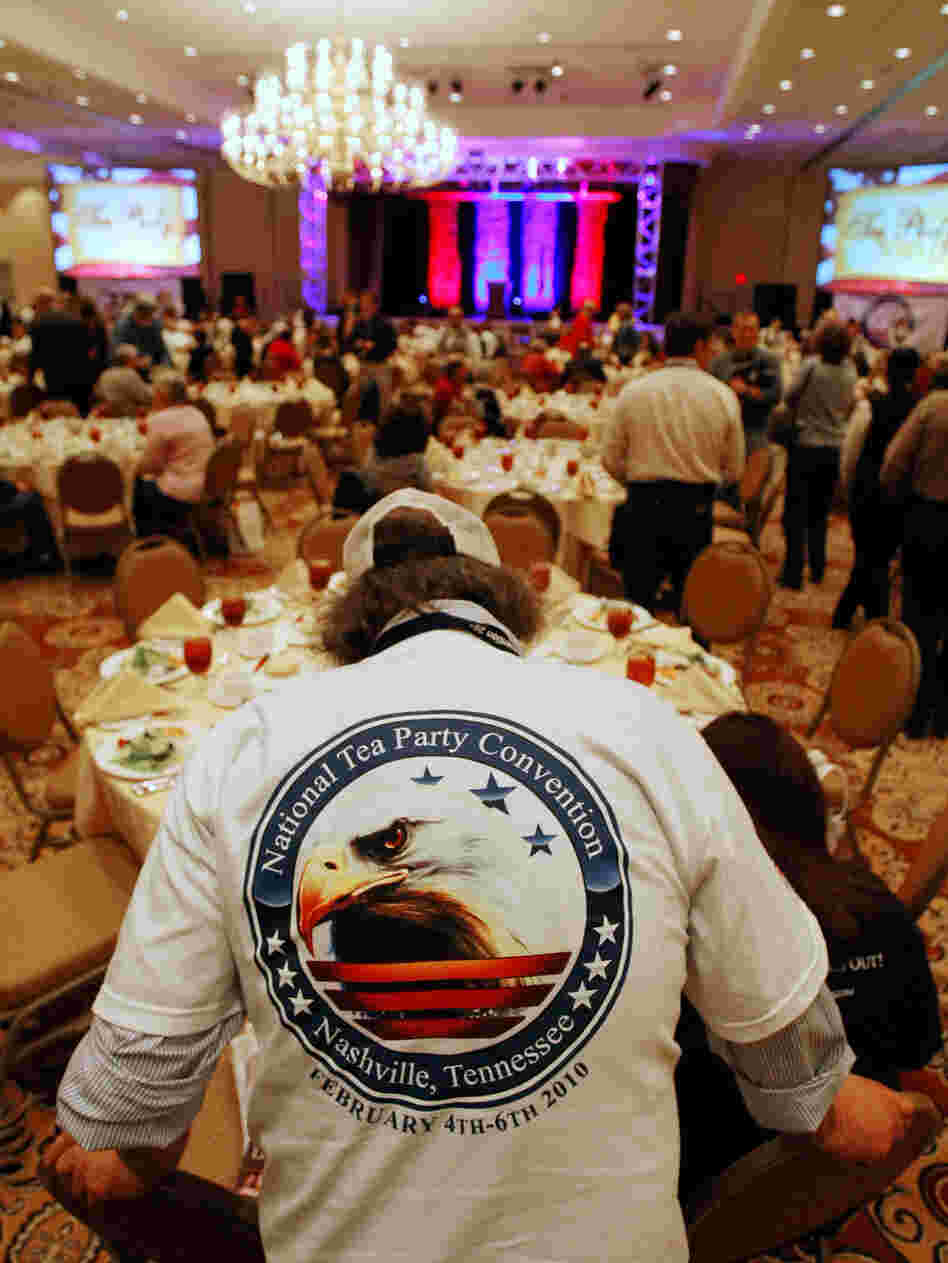 A man wears a National Tea Party Convention shirt. A man wears a National Tea Party Convention shirt.