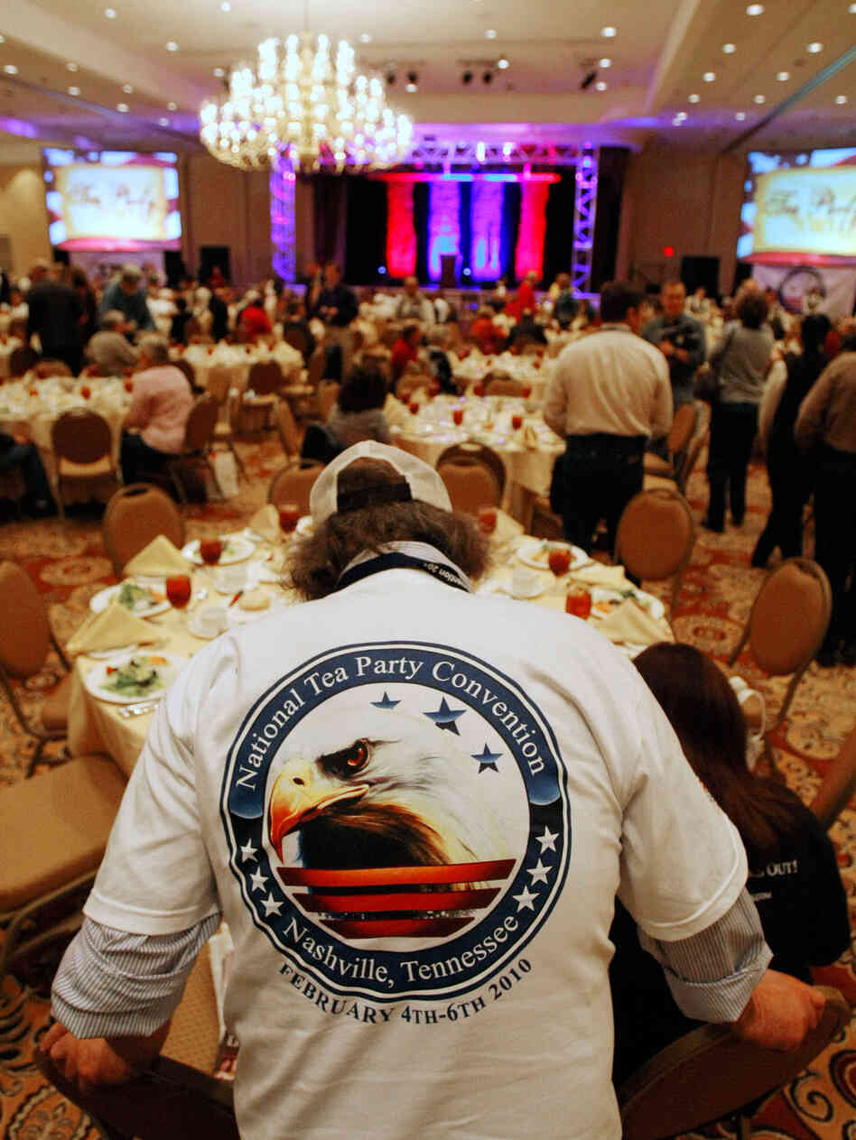 A man wears a National Tea Party Convention shirt. A man wears a National Tea Party Convention shirt.