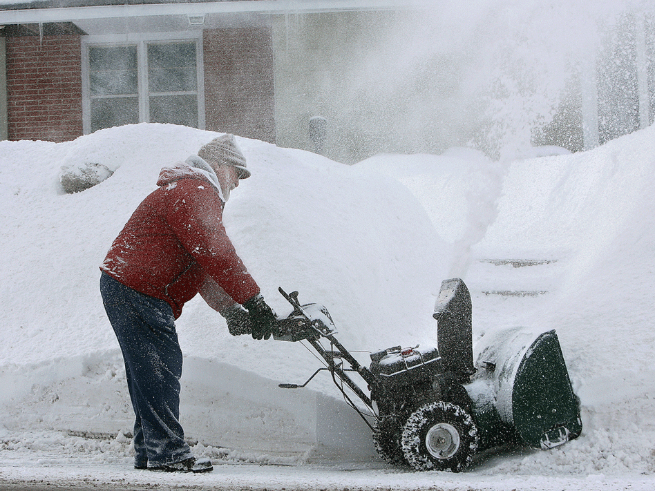 A man gets a faceful of snow as he cleans the driveway of his home in Mason City, Iowa.