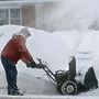 A man gets a faceful of snow as he cleans the driveway of his home in Mason City, Iowa.