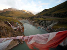 Tibetan prayer flags hang from a bridge crossing the Mekong River at sunrise. Tibetan prayer flags hang from a bridge crossing the Mekong River at sunrise.